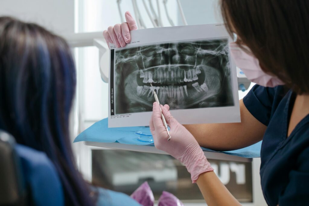 Dentist showing a dental X-ray to a patient to discuss cavity treatment.